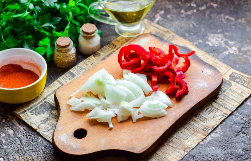 1. Этап. Рисовая лапша с мидиями: Очистите лук и сладкий перец, сполосните и нарежьте кубиками.