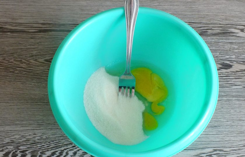 1. Этап. Овсяное печенье с яблоком на кефире: Смешайте в чаше яйцо, сахар и ванилин.