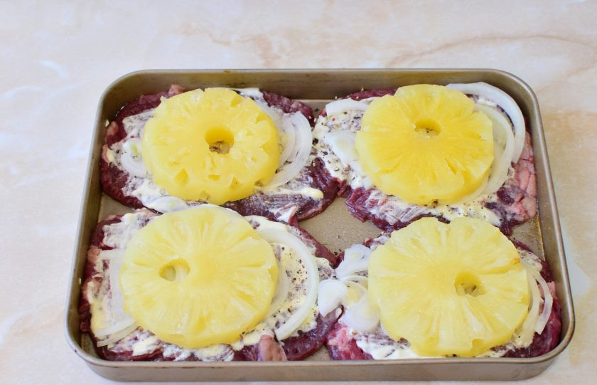 1. Этап. Телятина в духовке с ананасами: На каждый кусочек мяса выложите колечко ананаса.