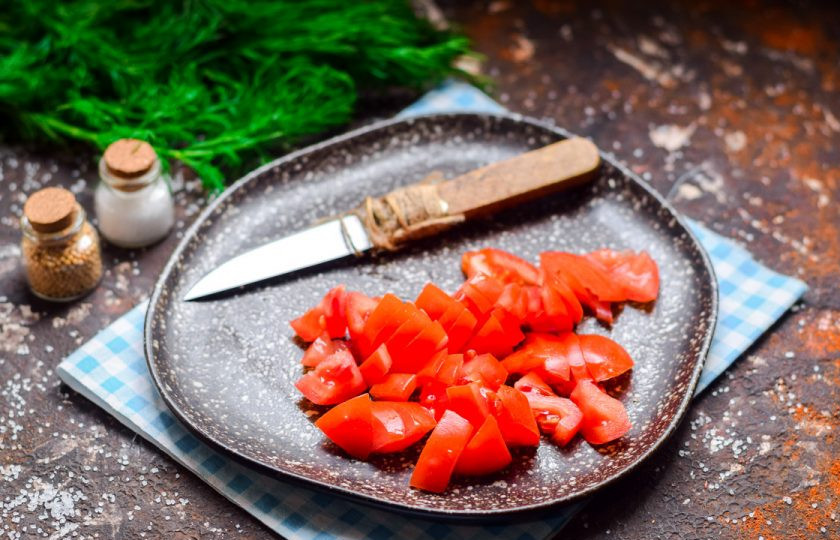 1. Этап. Салат из сыра, помидоров и крабовых палочек: Помидоры сполосните, просушите и нарежьте кубиками, излишки сока слейте.