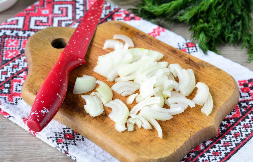 1. Этап. Куриная печень по-румынски: Нарежьте полукольцами репчатый лук.