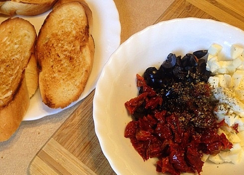 1. Этап. Брускетта: Выкладываем все ингредиенты в миску, добавляем базилик, соль, перец и оливковое масло. Можно использовать масло от вяленых помидоров.