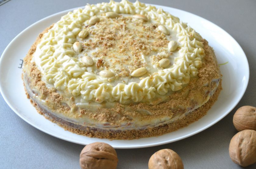 1. Этап. Самый простой морковный торт: Уложите верхний корж, смажьте верх и бока торта кремом, примерно 1/3 крема переложите в кондитерский мешок и украсьте торт сверху, можно присыпать остатками орехов. Бока можно обсыпать крошкой от печенья.