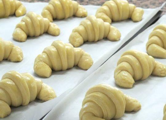 1. Этап. Круассаны из слоеного бездрожжевого теста: 4. Противень или форму для запекания застелите пергаментом. Выложите готовые круассаны из слоеного бездрожжевого теста в домашних условиях слегка, загибая внутрь края. Теперь в небольшой мисочке нужно взбить желток с сахаром (до однородности). Смажьте полученной смесью круассаны, отправьте противень с будущей выпечкой в разогретую духовку.