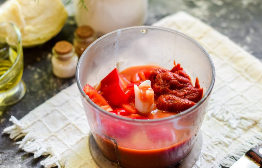 1. Этап. Казацкий борщ: Сразу приготовьте заправку. В чашу блендера переложите один нарезанный перец, томатный сок и пасту.