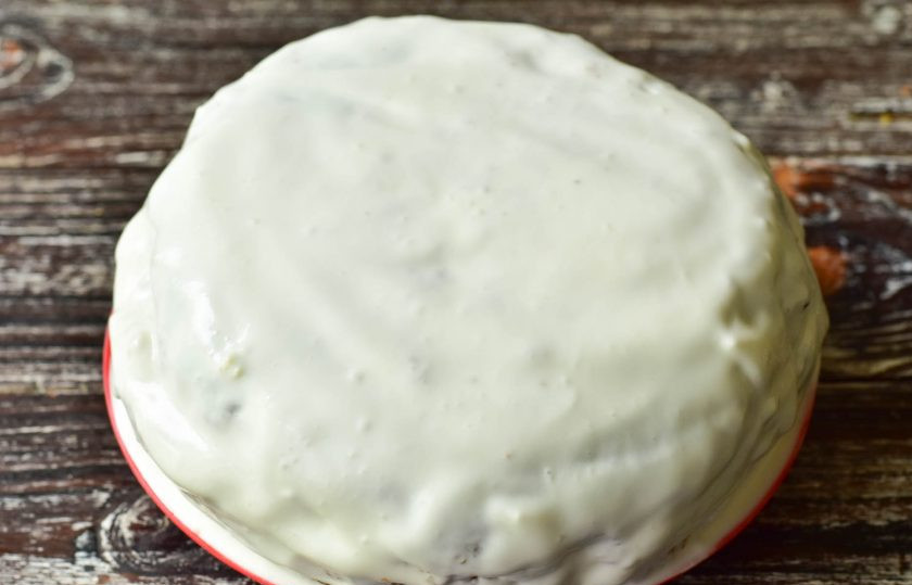 1. Этап. Морковный торт с ананасами: Промажьте второй корж, выложите снова ананасы, а затем полностью весь торт сверху и бока смажьте сметаной.