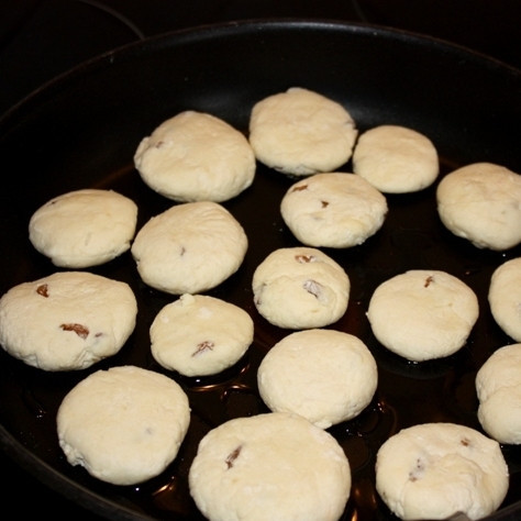 1. Этап. Сырники с изюмом (без яиц): Разогреваем в сковороде немного масла, выкладываем в него наши сырники. Обжариваем с одной стороны до румяности, примерно 3-5 минут.