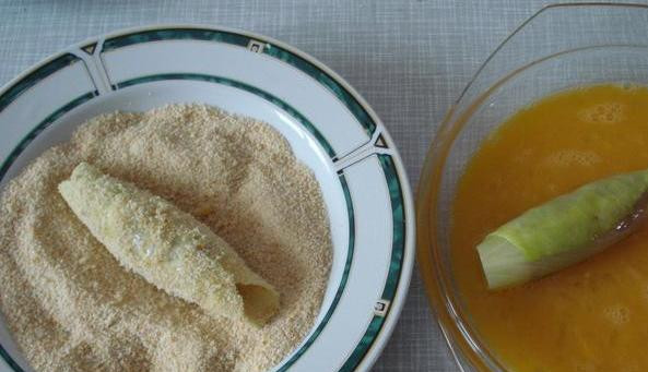 1. Этап. Сосиски в капустных листьях: Заворачиваем каждую сосиску в капустный лист, обмакиваем во взбитые яйца, а затем обваливаем в сухарях.