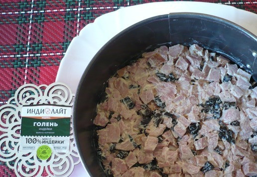 1. Этап. Салат-закуска Зимняя сказка: Салат-закуску я буду готовить слоями, для этого берем разъемную форму (d-18 см) поставить её на блюдо. Первый слой выкладываем смесь варено-копченой голени индейки и чернослива.