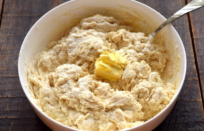 1. Этап. Булочки Столичные: Когда мука увлажнится, добавьте мягкое сливочное масло, перемешиванием соедините его с тестом.