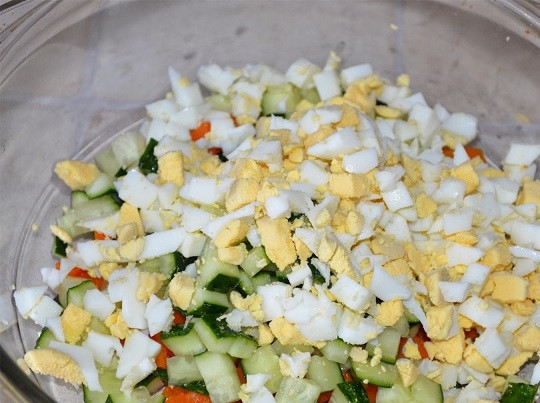 1. Этап. Салат с печенью трески: 2. Очистите яйца, морковь, вымойте огурчик и все нарежьте небольшими кубиками. Выложите в глубокий салатник.