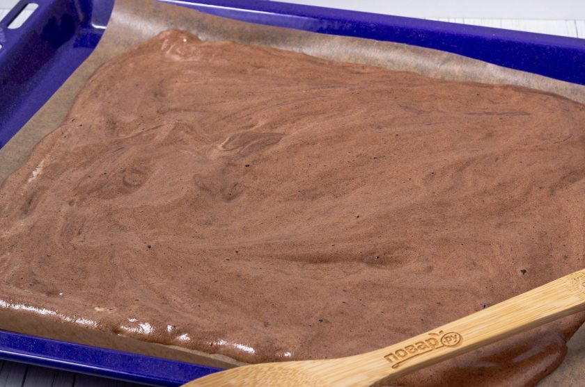 1. Этап. Шоколадный бисквитный рулет: Распределите тесто на противень с пергаментом и выпекайте 12-15 минут при температуре 180 градусов.