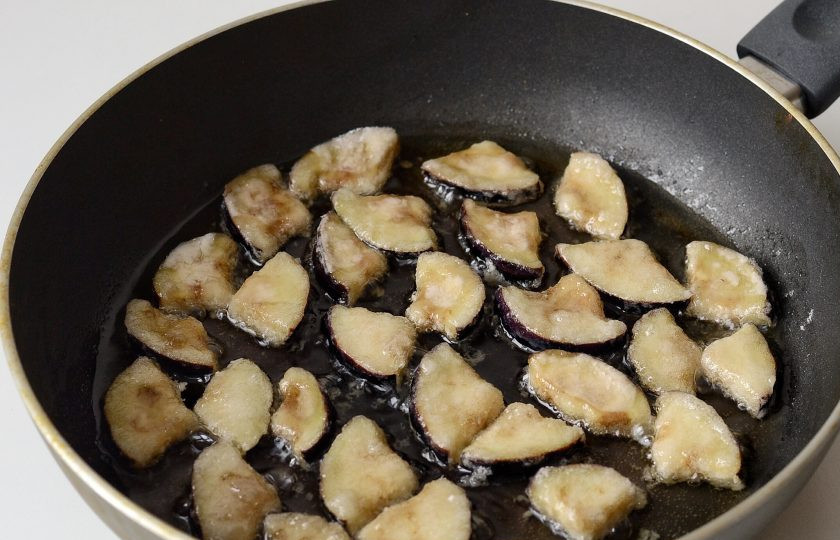 1. Этап. Салат с хрустящими баклажанами и помидорами: Обжарьте ломтики баклажанов в большом количестве масла до хрустящей корочки. Затем выложите на бумажное полотенце.