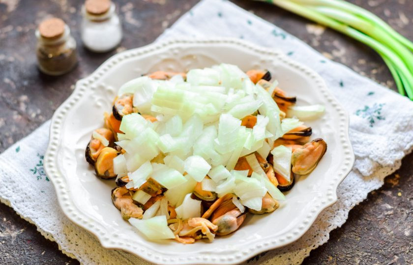 1. Этап. Мидии жареные с луком: Очистите лук, сполосните и просушите. После нарежьте лук небольшими кубиками.