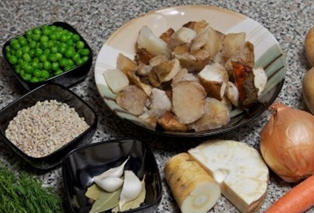 1. Этап. Грибной суп из замороженных грибов: Лук, морковь, чеснок, картофель, корень сельдерея и петрушки помойте, очистите и порежьте. Приготовьте зеленый горошек, перловую крупу отварите и дайте стечь на дуршлаге.