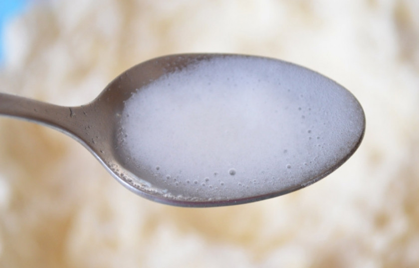 1. Этап. Тесто для рогаликов: 3. В ложке уксусом гашу щепотку соды, добавляю ее в миску с мучной крошкой.