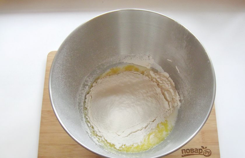 1. Этап. Белая глазурь для булочек: Муку просейте и всыпьте в тесто.