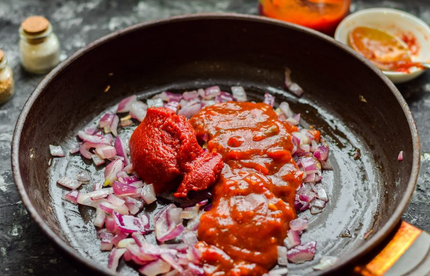 1. Этап. Соус для плова: Добавьте к луку томатную пасту, аджику, сухой чеснок, соль и перец.