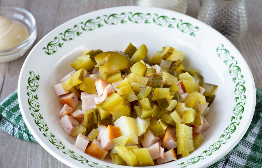 1. Этап. Салат с карбонатом: Соленые огурцы нарежьте кубиками и добавьте в салат.