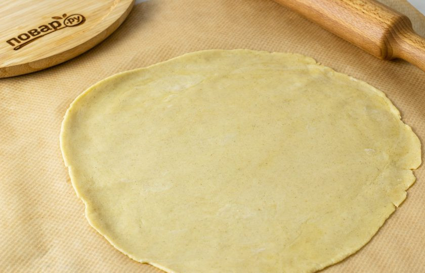 1. Этап. Галета с клюквой: Раскатайте тесто на пергаменте толщиной 3-4 мм.