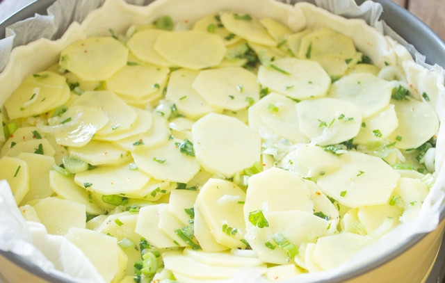 1. Этап. Закрытый пирог с картошкой: 3. Жаропрочную форму смажьте маслом или застелите пергаментом. Раскатайте тесто, выложите на дно. В данном случае в рецепте приготовления закрытого пирога с картошкой используется слоеное бездрожжевое тесто. Распределите сверху начинку.