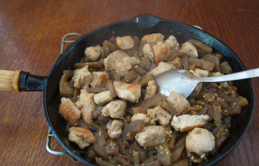 1. Этап. Рагу из баклажан с мясом: Добавьте к обжаренному мясу очищенные от хвостиков и кожицы баклажаны. Можно взять замороженные. Накройте сковороду крышкой и тушите все на среднем огне 5 минут.