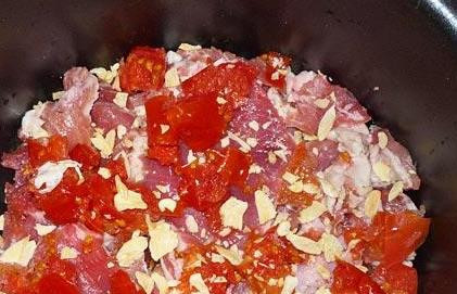 1. Этап. Жаркое из свинины в мультиварке: Теперь выкладываем порезанные в произвольном порядке томаты, сверху присыпаем измельченным чесноком.