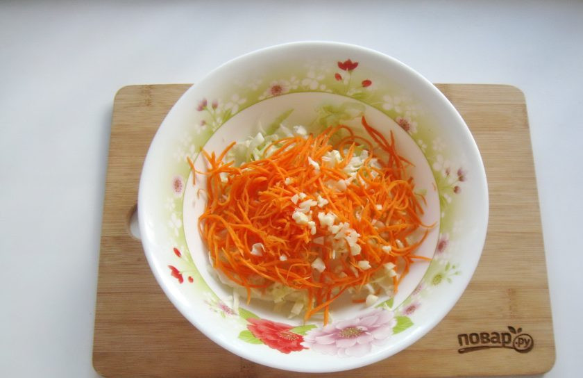 1. Этап. Капуста с чесноком и морковью: Чеснок очистите, измельчите любым способом и выложите в салат.