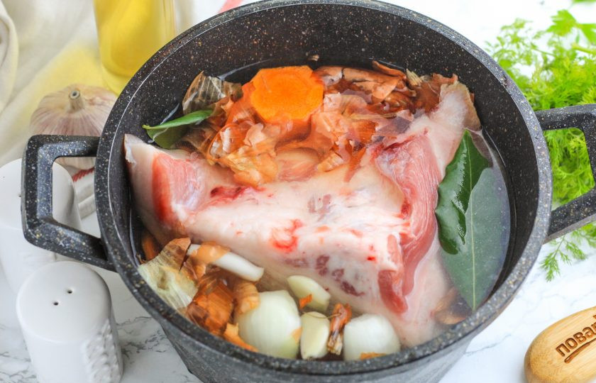 1. Этап. Щековина свиная в луковой шелухе: Промойте щековину в воде, соскоблите кожу от нагара и еще раз промойте. Сделайте глубокие надрезы аж до кожи, чтобы рассол попал и внутрь куска мяса. Поместите в казан, всыпьте соль и залейте теплой водой.