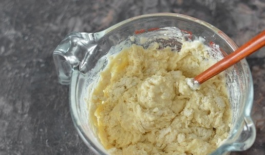 1. Этап. Булочки сахарные из ночного теста: Влейте все смешанные жидкие ингредиенты в муку и лопаточкой начните замешивать тесто.