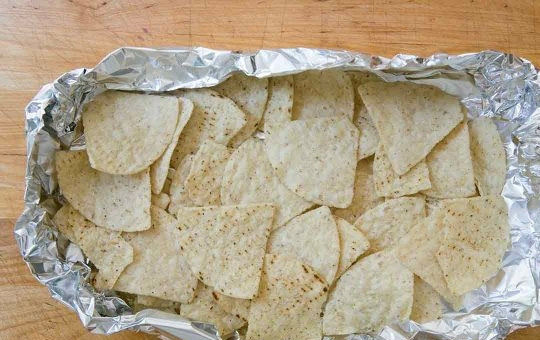 1. Этап. Куриные начос: 2. Выложите в лодочку из фольги нижним слоем чипсы.