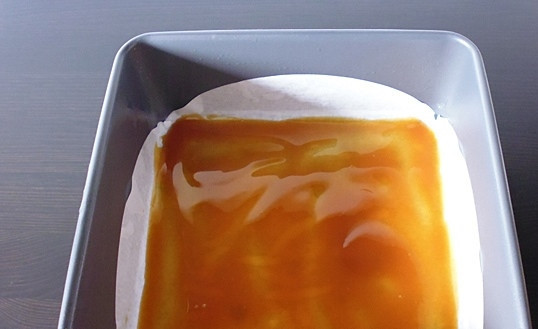 1. Этап. Пирог с персиками и карамелью: Дно противня застелите бумагой для выпечки и равномерно смажьте карамелью.