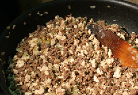 1. Этап. Лазанья с мясом и овощами: Лук и чеснок обжарьте на масле до прозрачности и добавьте фарш, жарьте на сильном огне, все время помешивая.