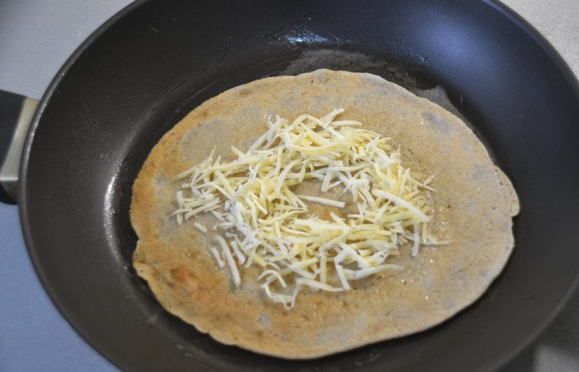 1. Этап. Яичница в блинах: Выложите на блин натёртый сыр в виде окружности с углублением в центре.