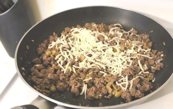 1. Этап. Фаршированные грибы с оливками и орехами: Начинку из фарша обжарьте на сковороде 15-20 минут, пока фарш не станет мягким. Добавьте натертый сыр, хорошо все перемешайте.