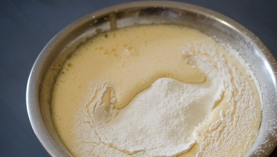 1. Этап. Простой рецепт шарлотки с яблоками: В массу просейте муку с разрыхлителем через сито. Хорошо перемешайте тесто.