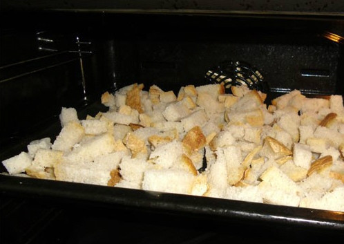 1. Этап. Сухарики в духовке: Насыпаем нарезанный хлебушек на сухой поднос и ставим в разогретую до 180 градусов духовку. Выпекаем на самой верхней полке на слабом огне. Так сухарики хорошо подсушатся и не сгорят. Проверяйте их каждые 5-10 минут и переворачиваем.