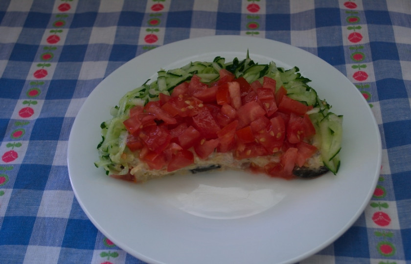 1. Этап. Салат Арбузная долька: 4. Мелко нарежьте помидоры кубиком. Лучше брать упругий, мясистый помидор. Он меньше дает сока и более плотный. Свежий огурец натрите на терке. Центральную часть дольки декорируйте помидором, а край - огурцом.