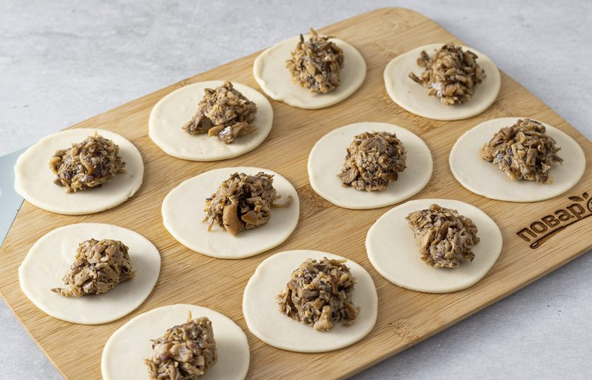 1. Этап. Вареники с вешенками: Тесто раскатайте толщиной 3-4 мм. Вырежьте кружки. На каждый выложите примерно по 1 ч.л. начинки.