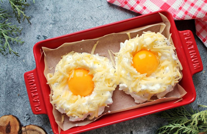 1. Этап. Яйца в пуховом гнезде: Белки посыпьте тертым сыром, поперчите и выложите в углубление по одному яйцу.