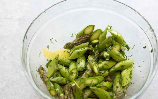 1. Этап. Рецепт семги в духовке с картошкой: Тем временем нарезаем спаржу на небольшие кусочки. Выкладываем ее в миску, туда же добавляем укроп, давленый чеснок, цедру лимона, соль и немного оливкового масла.