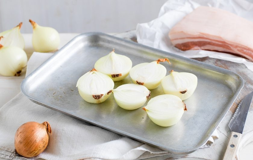 1. Этап. Итальянская поркетта: 1. Разрежьте очищенный лук пополам и поместите на противень для выпекания.