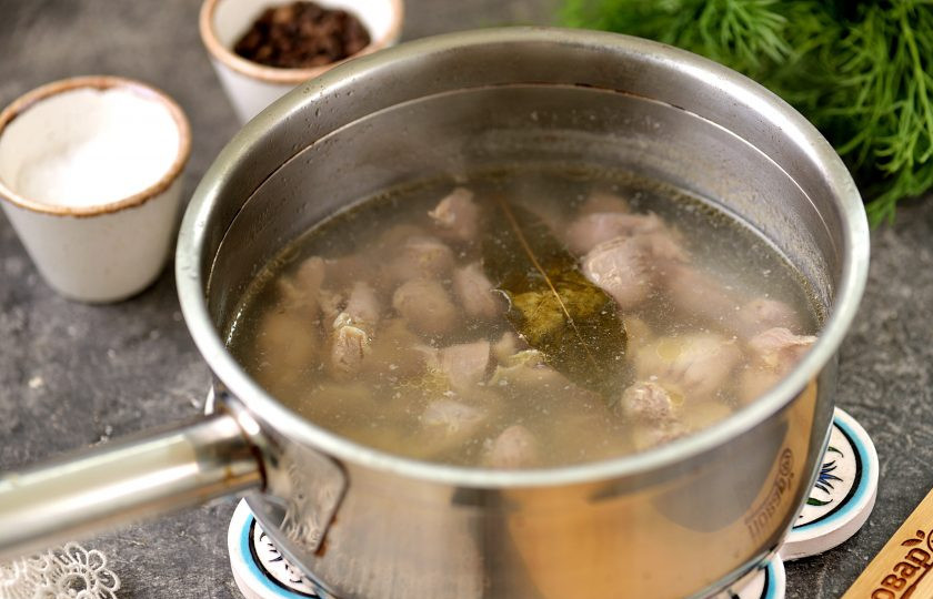 1. Этап. Бюджетный салат с куриными желудками и жареными грибами: Желудки промойте под проточной водой, срежьте весь жир, очистите субпродукт с внутренней стороны от остатков горькой пленки. Отварите желудки минут 40-50 с добавлением лаврового листа и перца горошком, воду можно слегка подсолить.