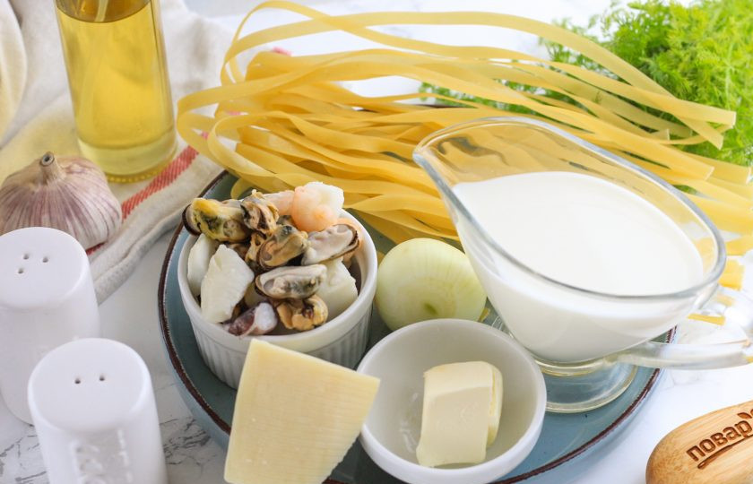 1. Этап. Сырно-сливочная паста с морепродуктами: Подготовьте указанные ингредиенты. Сыр можно использовать любого сорта, а сливки лучше выбирать 10-20%. Очистите лук и зубчик чеснока от кожуры.