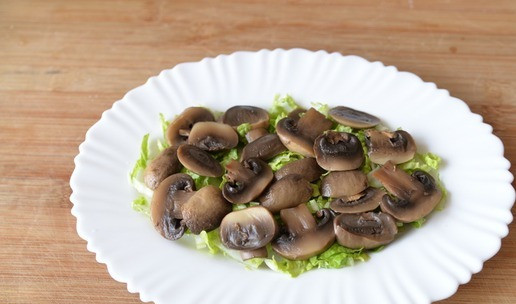 1. Этап. Салат Княжий град: Берём половину указанного количества маринованных шампиньонов, режем пластинами, кладём сверху капусты.