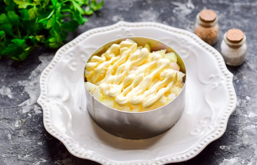 1. Этап. Салат Мимоза с кальмарами: Смажьте слой лука майонезом.