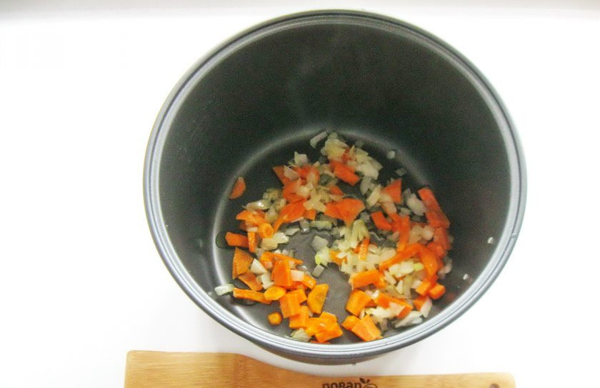 1. Этап. Гречка с мясом и грибами в мультиварке: Налейте рафинированное масло и поджарьте лук с морковью в течение 10 минут.
