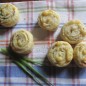 Закусочные булочки с беконом и сыром Духовку разогреть до 180 градусов. Бекон обжарьте на сухой сковороде, пока он не станет хрустящим, выложите его на салфетку, чтобы удалить лишний жир. Когда бекон остынет, наломайте его руками на небольшие кусочки. Нарежьте зеленый лук тонкими кольцами. Раскатайте тесто в прямоугольник размером примерно 20x30 см. и толщиной 3-4 мм. Посыпьте тесто беконом, сыром и луком. Начиная с короткой стороны скатайте тесто в плотный рулет. Острым ножом разрежьте рулет на части толщиной 2-2,5 см. Переложите булочки на противень и выпекайте до золотистого цвета.
