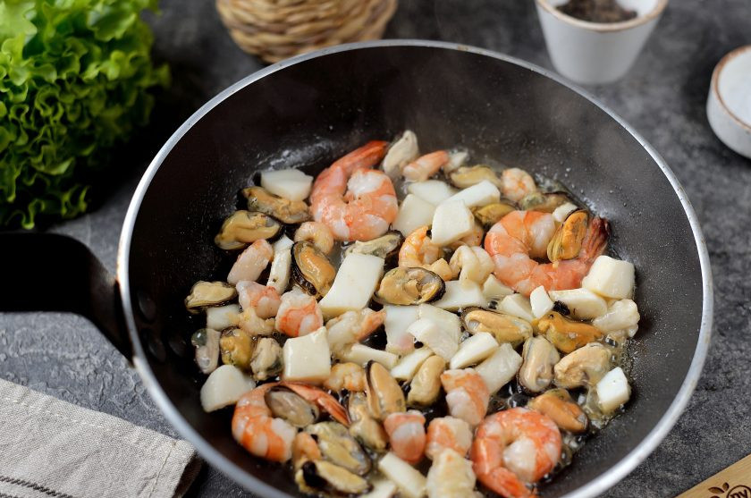 1. Этап. Салат с морепродуктами и красной икрой: Разогрейте в сковороде небольшое количество растительного масла, обжарьте в нем морепродукты на сильном огне около минуты.