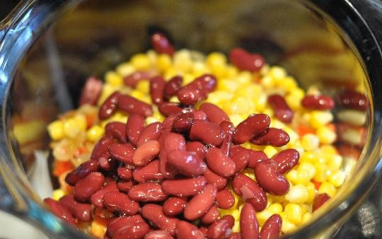 1. Этап. Салат с фасолью и кукурузой: Вскрываем банки с консервированными фасолью и кукурузой. Сливаем с них жидкость, а зерна высыпаем в глубокую миску.